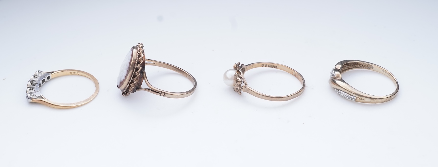 A collection of four rings and a pendant